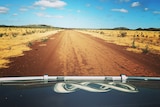 View of an open road from a car with ABC logo on bonnet.