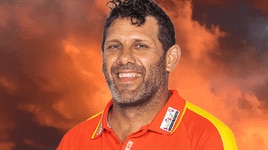 Man with brown hair and light eyes smiling in a Gold Coast Suns uniform