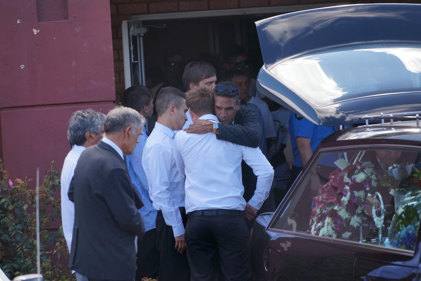 Mourners comfort each other at Elijah Doughty's funeral.