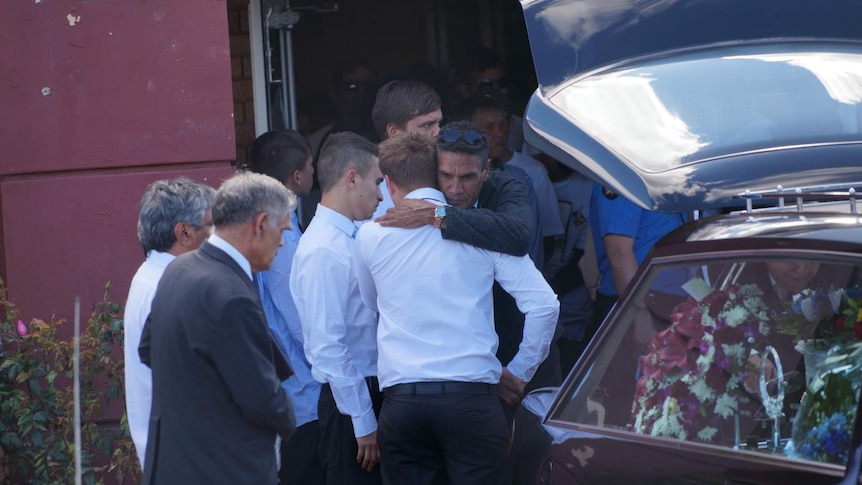 Mourners comfort each other at Elijah Doughty's funeral.