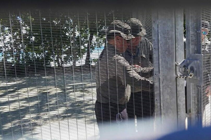 Two guards lock the gates at Manus Island detention centre.