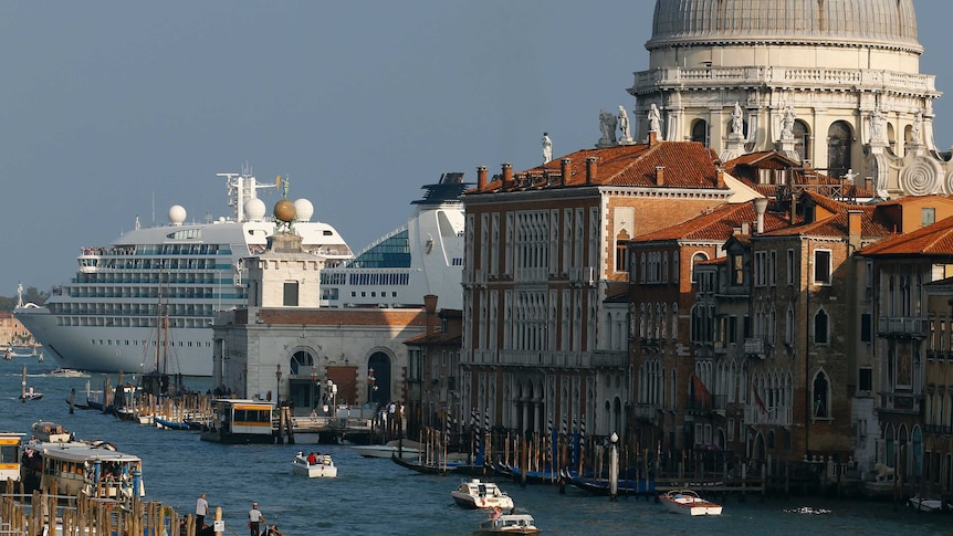 La nave da crociera sullo sfondo ha all'incirca le dimensioni di una grande cupola veneziana, mentre la gondola e il vaporetto passano attraverso un canale.