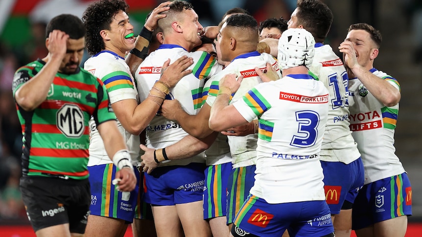 A group of rugby league players celebrate a try 