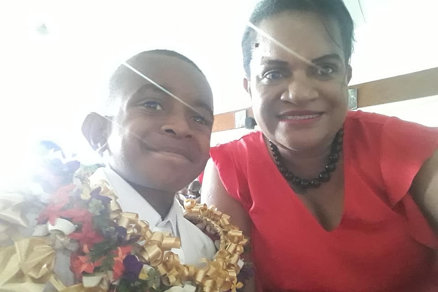 A Fijian woman and her young son smile.