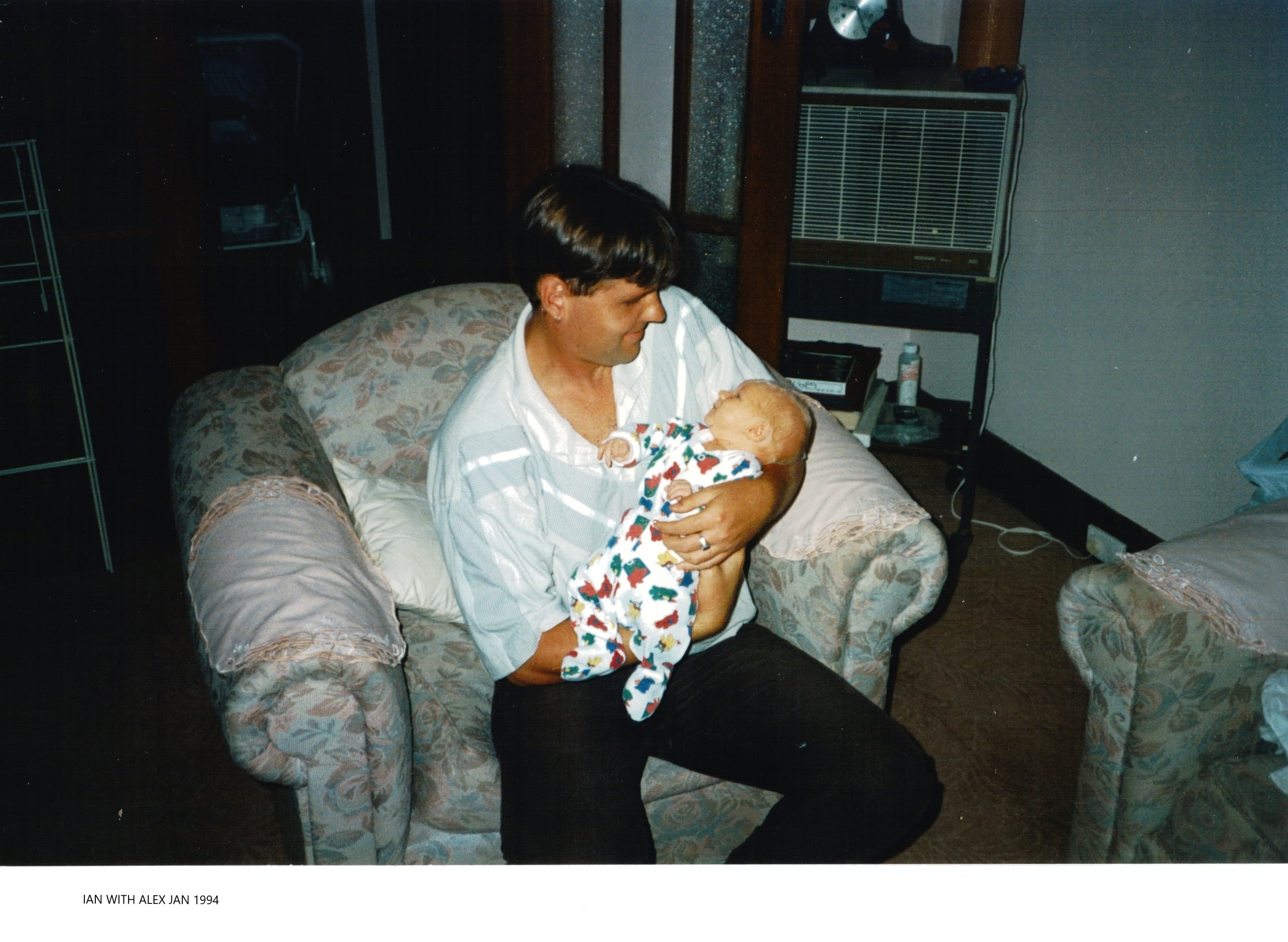 A young man holds an infant.