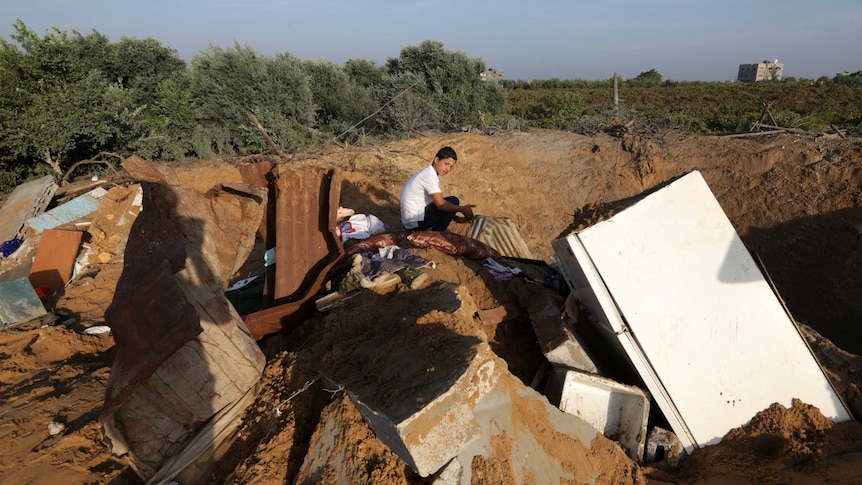 Palestinian boy inspects the damage after an Israeli retaliatory air strike