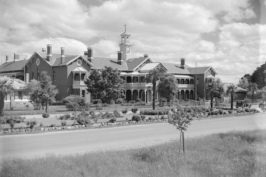 A black and white picture of a large Victorian-style building.