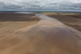 An aerial view of muddy, wet paddocks after the rain