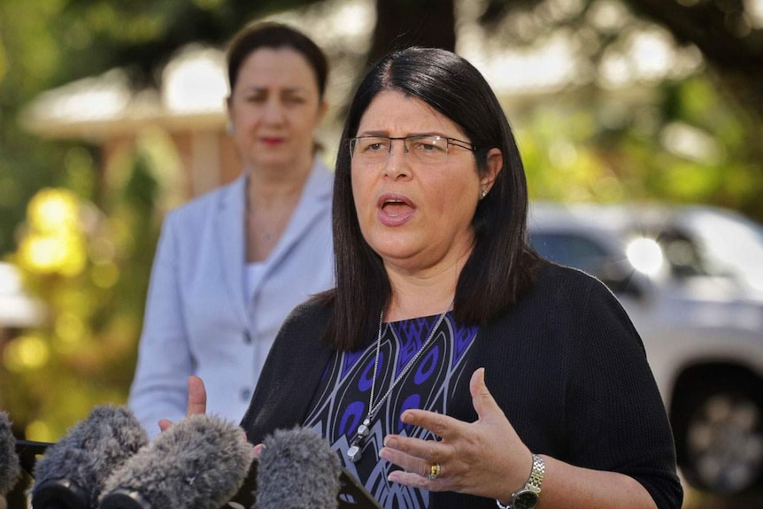 Queensland Education Minister Grace Grace, with Premier Annastacia Palaszczuk in the background, speaks at a press conference.