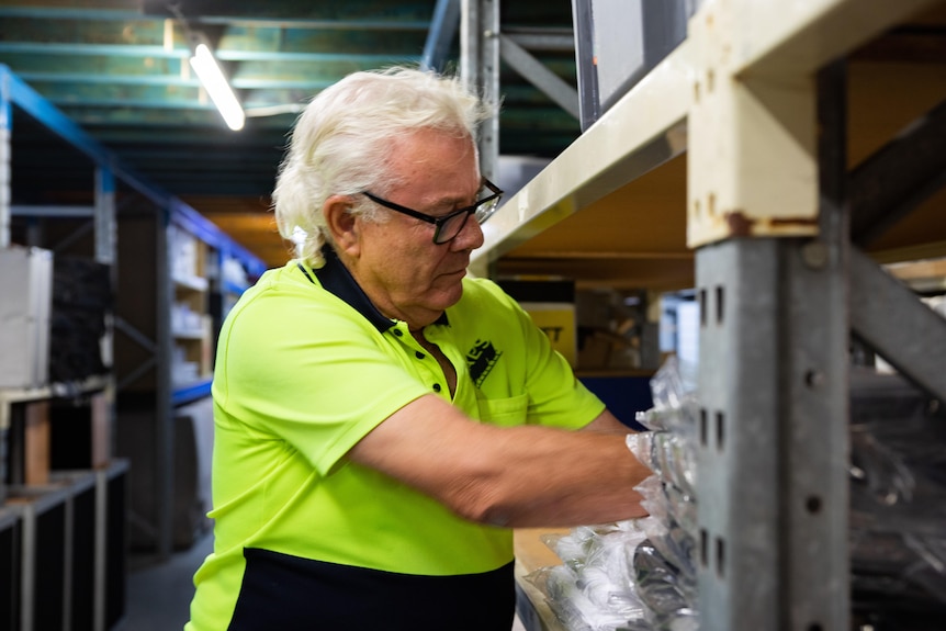 Edward Schimmel revisando cosas en un estante en su almacén.