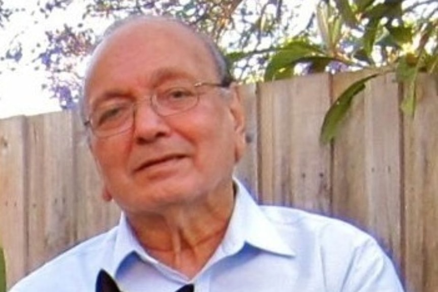 Portrait photo of a man wearing glasses holding a cat