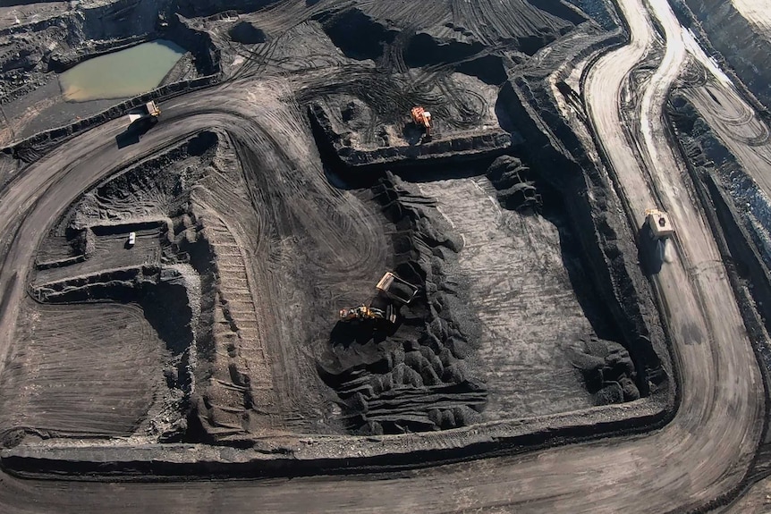 Trucks and loaders work inside the New Acland Mine West Pit, June 2020.