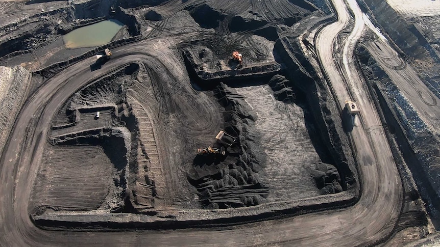 Trucks and loaders work inside the New Acland Mine West Pit, June 2020.