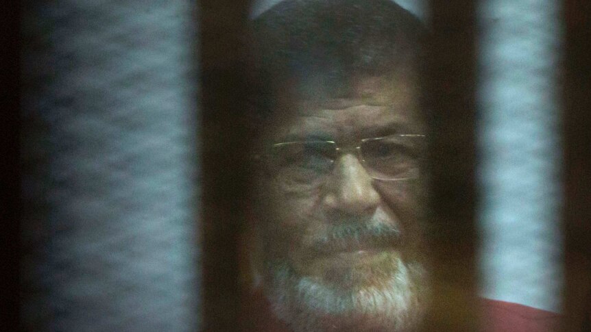 Mohammed Morsi sits behind bars in a Cairo jail.