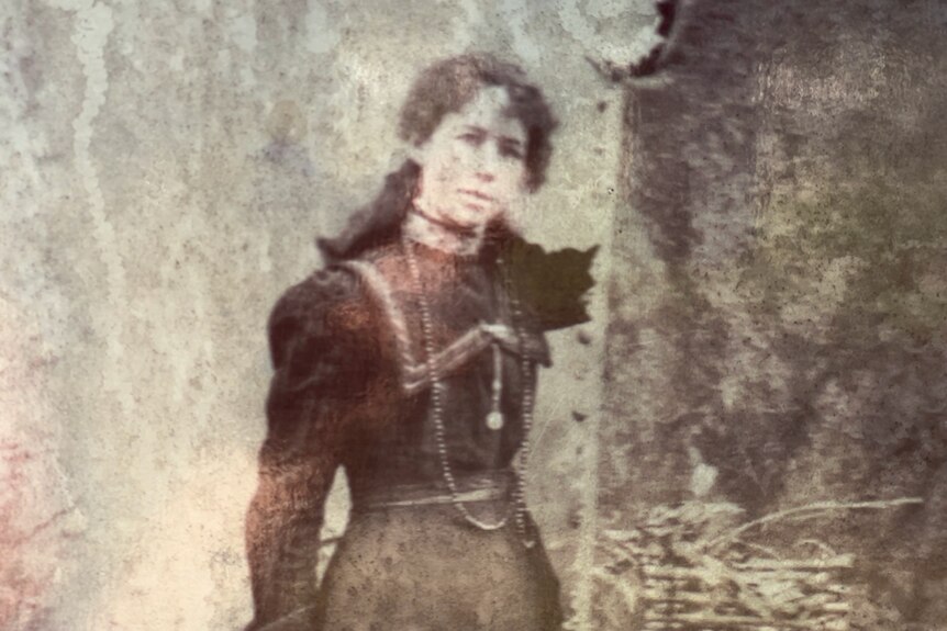An archival photo of Maria Langley aged 18. She's got curly hair, a neckalce and a 19th century victorian era dress,