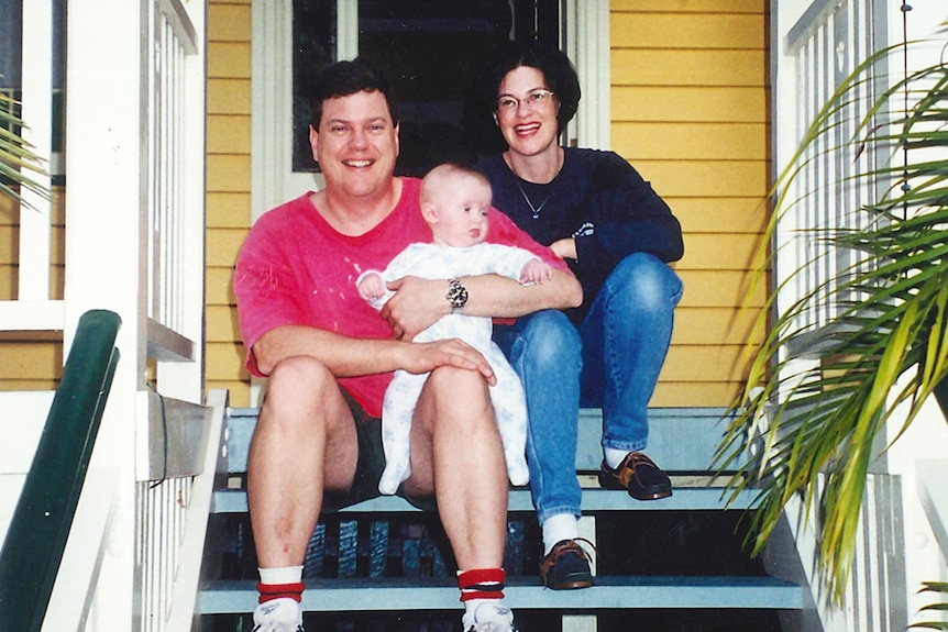 Tim Nicholls with wife Mary and son Jeremy sit on front stairs of their second home in Greenslopes
