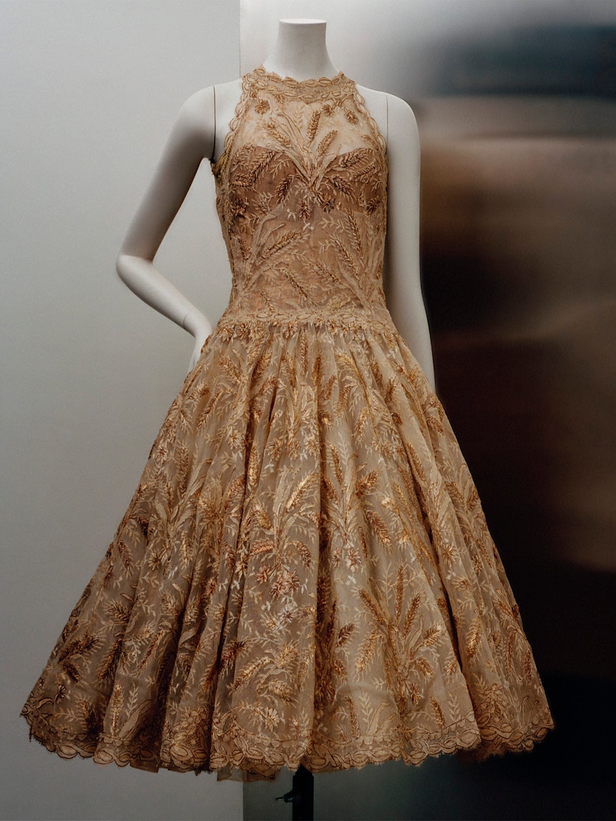 A mannequin in an 1960s evening dress, golden lace and full skirt