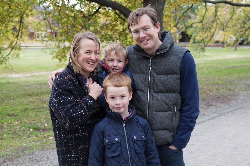 A man and woman and two boys smiling