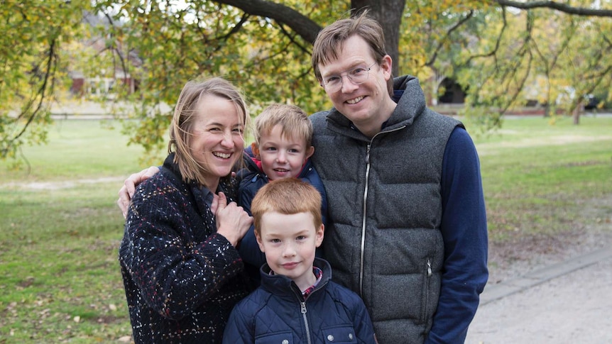 A man and woman and two boys smiling