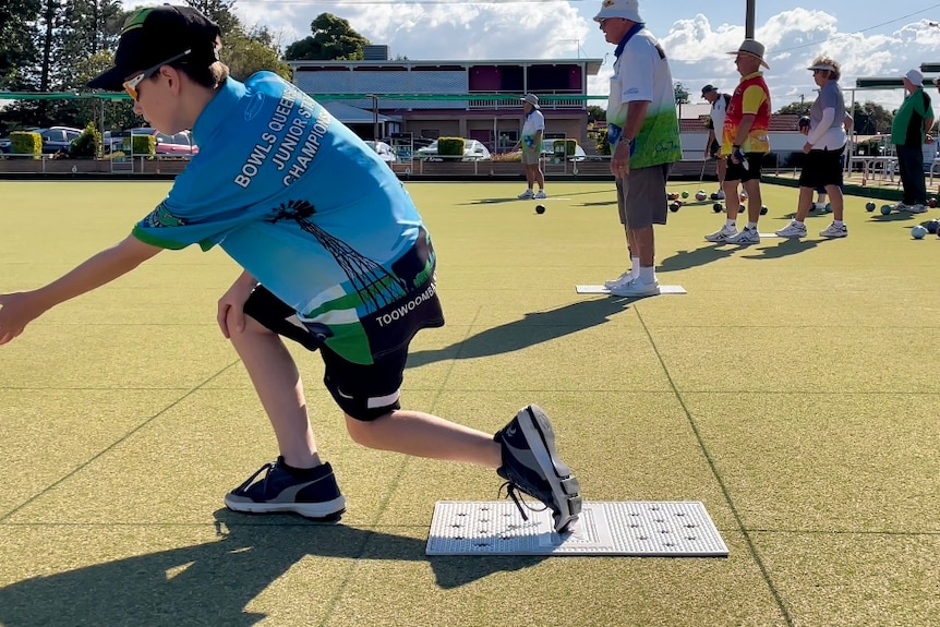 Young boy playing lawn bowls 