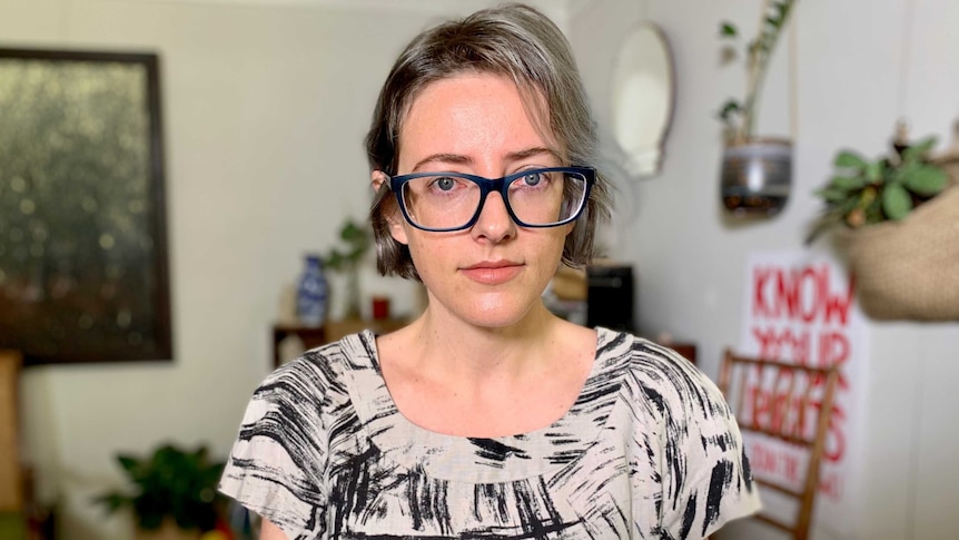 Woman wearing glasses stands in living room