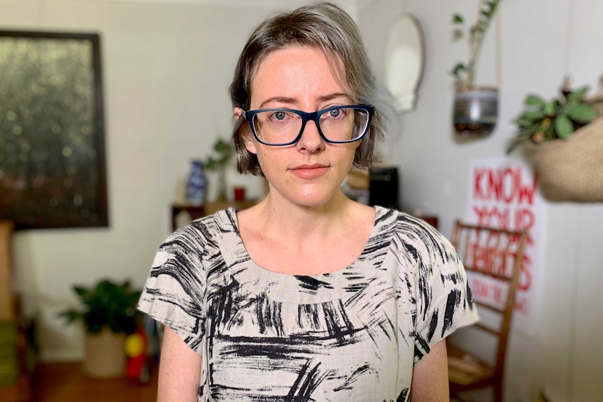 Woman wearing glasses stands in living room