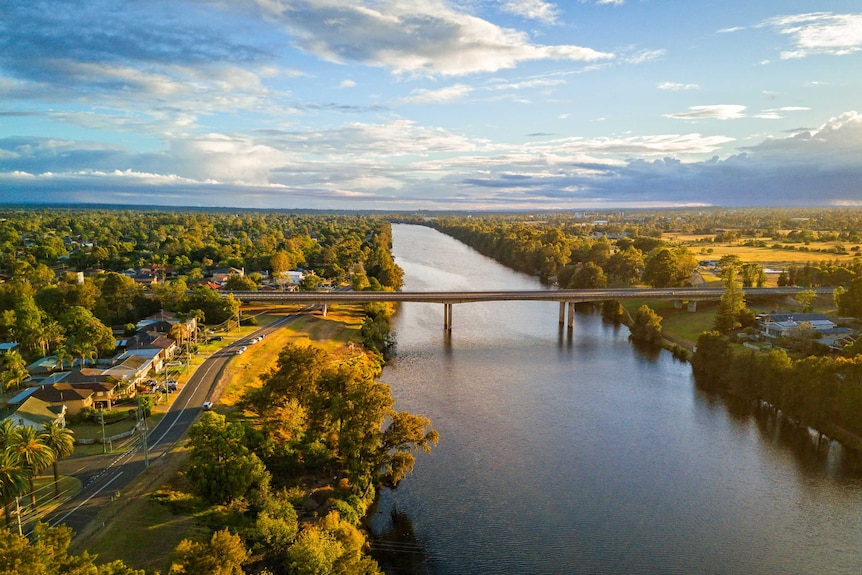 Scenic views of a river with a blue sky and wide green landscape.