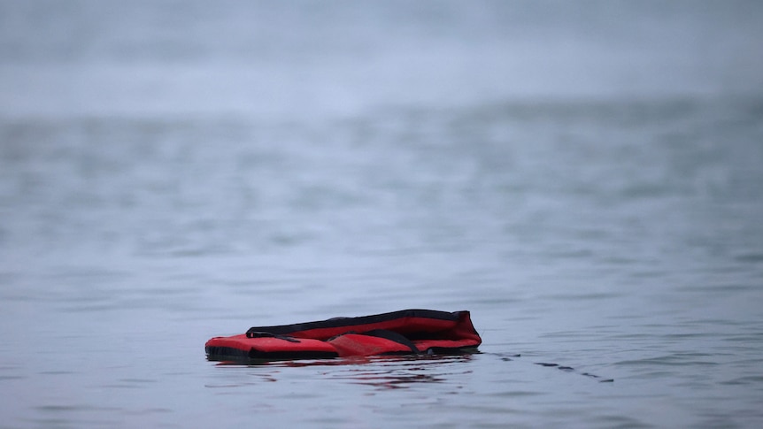 A liftjacket floats on a still body of water.