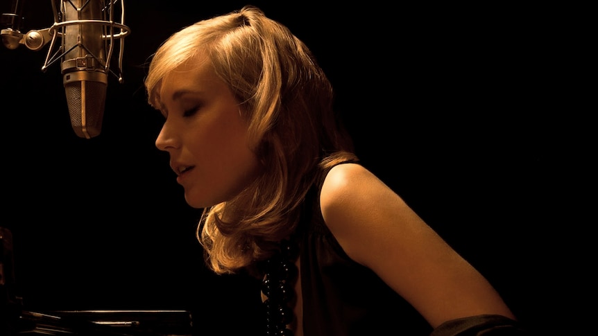 A colour shot of Sarah McKenzie in a black dress at the piano