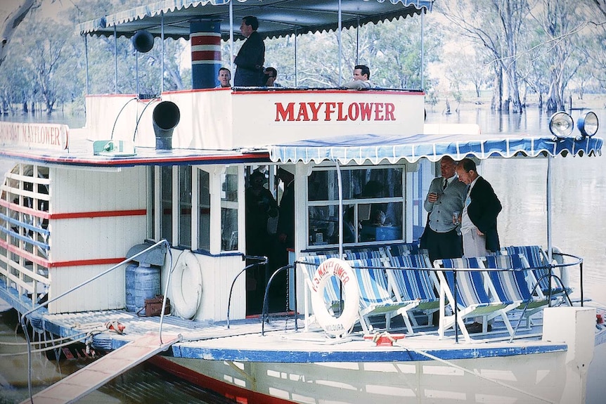 An old photo of the paddle boat with men standing on deck.
