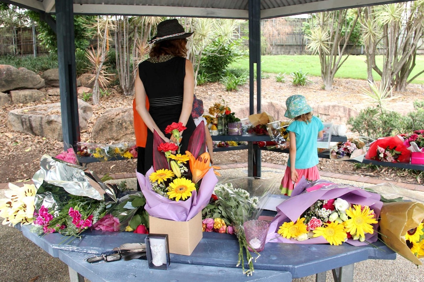 People visit the memorial to murdered French student, Sophie Collombet, at a rotunda in South Brisbane.