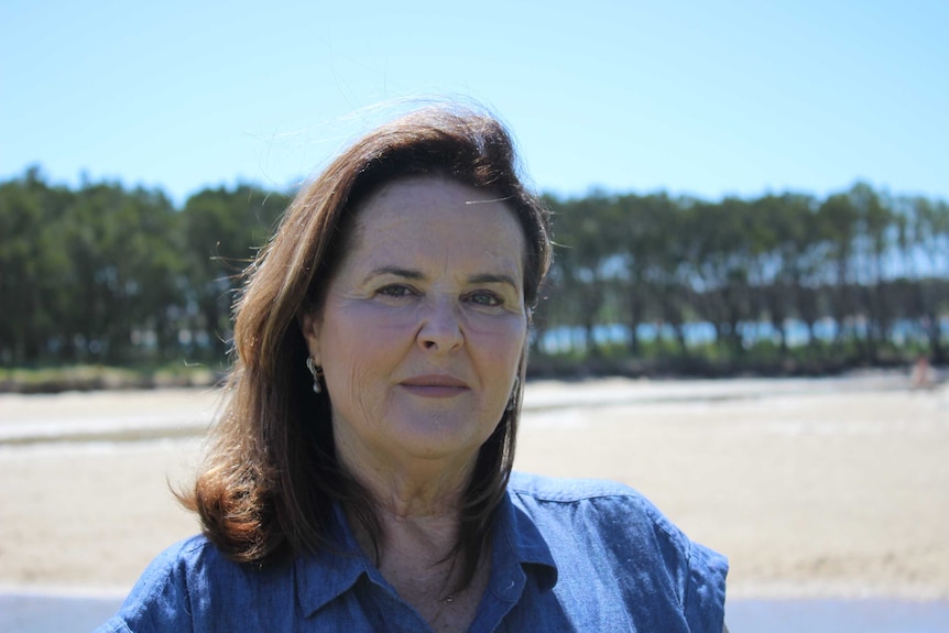 Woman standing look at camera with Lake Illawarra in the background.