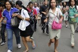 Workers and students run after they feel the magnitude 6.7 earthquake