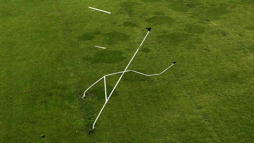 A set of rugby goal posts stand twisted by Cyclone Yasi in Tully in Far North Queensland on February 3, 2011.