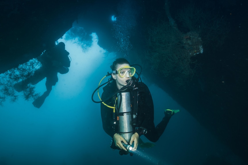 A scuba diver exploring an underwater shipwreck. 
