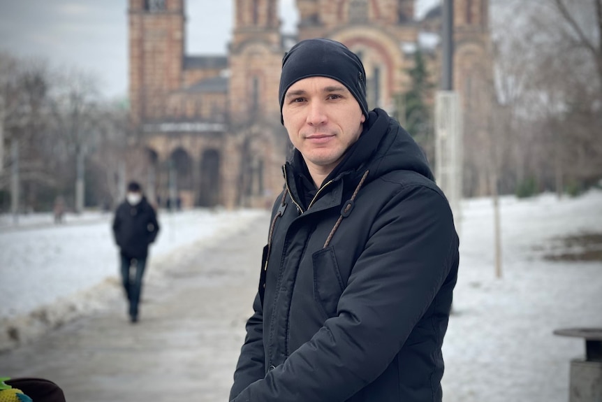 A father in a beanie poses for a photo while out walking in Belgrade