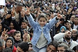 Girl gives peace sign as Tunisians mark uprising anniversary