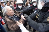 A protester debates with the police during a demonstration against COVID-19 restrictions in Vienna, Austria.