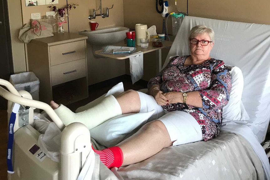 A woman with a broken ankle in a hospital bed