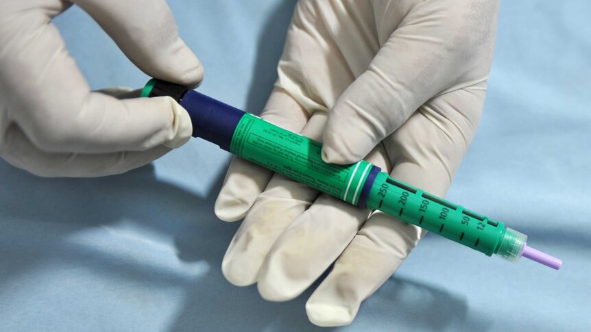 A medical assistant holds an insulin pen administered to diabetes patients generic
