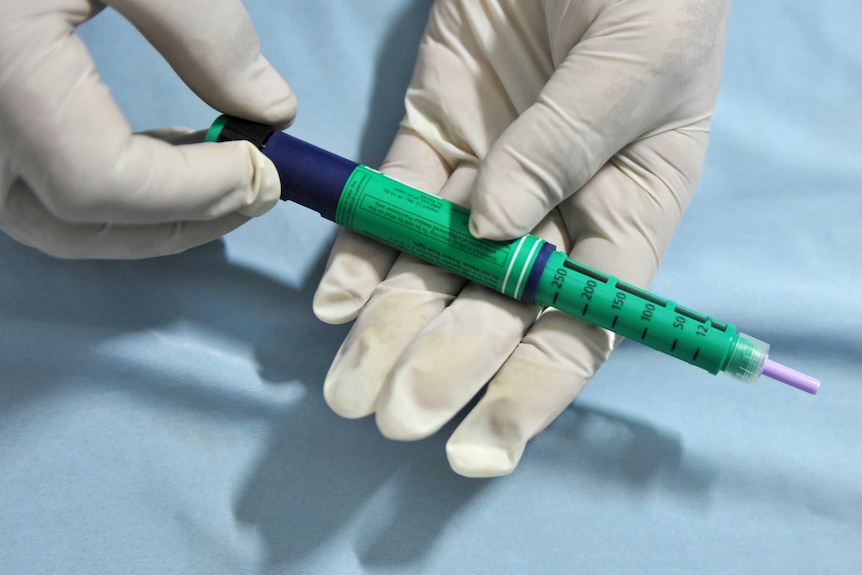 A medical assistant holds an insulin pen administered to diabetes patients generic