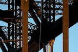 A protester abseils down from the arch of the Sydney Harbour Bridge