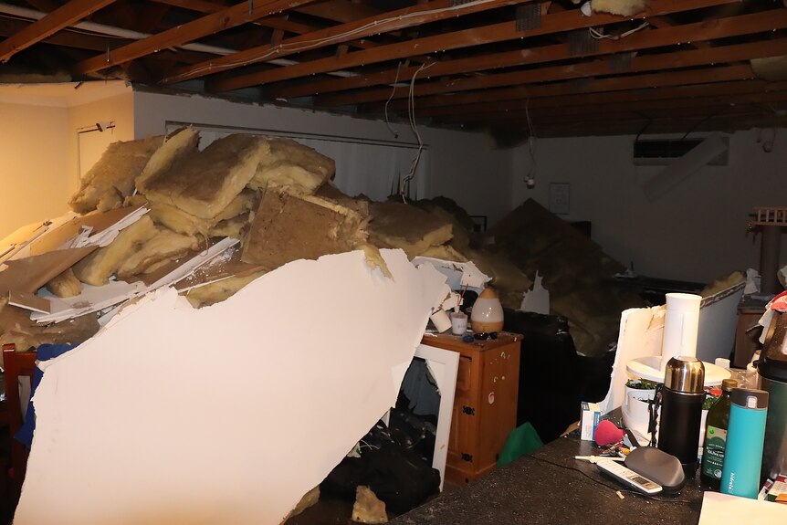 Debris from a collapsed ceiling lies across a living room.
