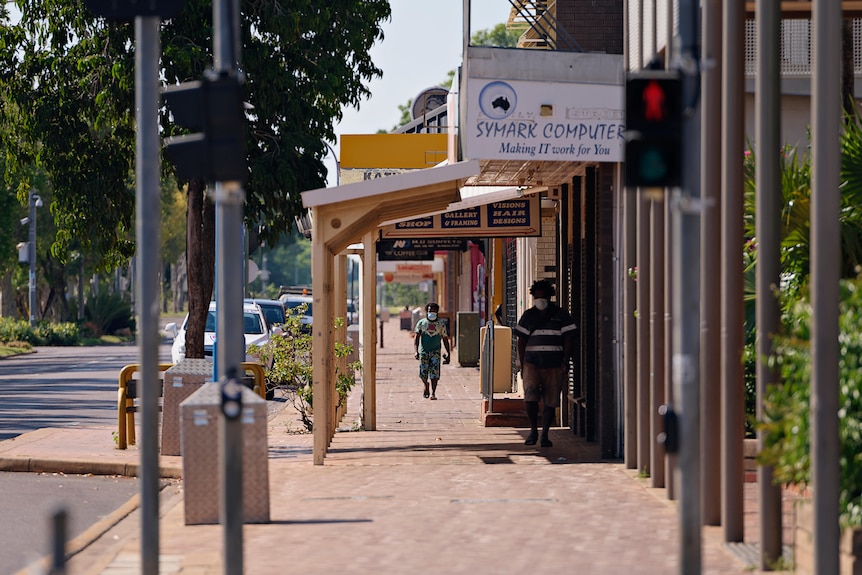 Residents wearing masks walking up the main street during the COVID-19 outbreak lockdown of Katherine.