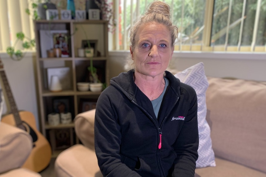  A woman with blonde hair sits on a couch