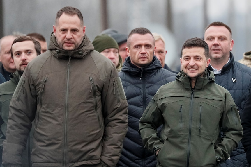 A group of men in khaki clothing walk together