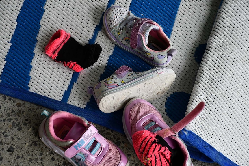 A group of children's shoes on a mat