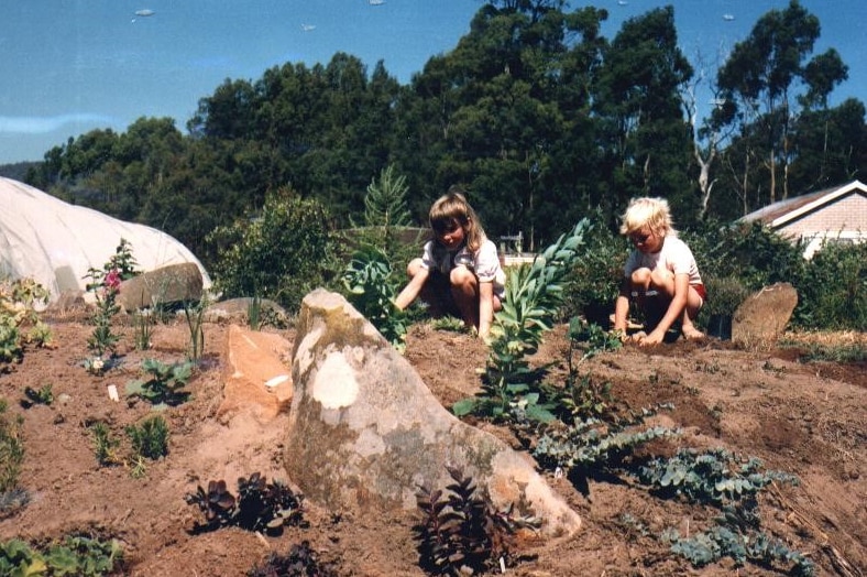 Two young girls outside with some plants