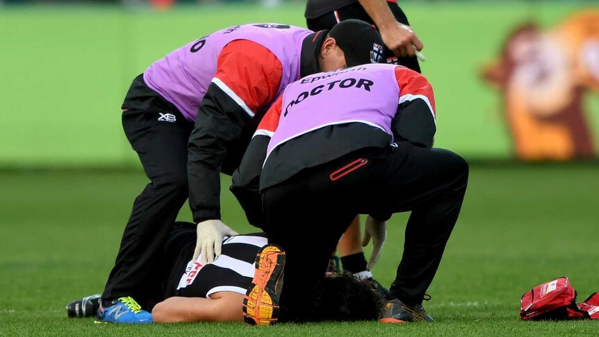 St Kilda's Dylan Roberton lies on the ground after collapsing against Geelong