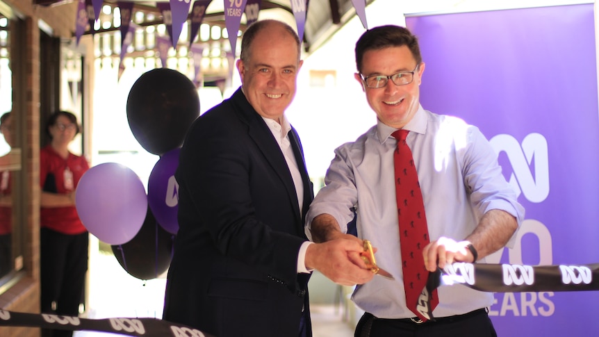 David Anderson and David Littleproud hold a pair of large scissors at a piece of black ribbon. 